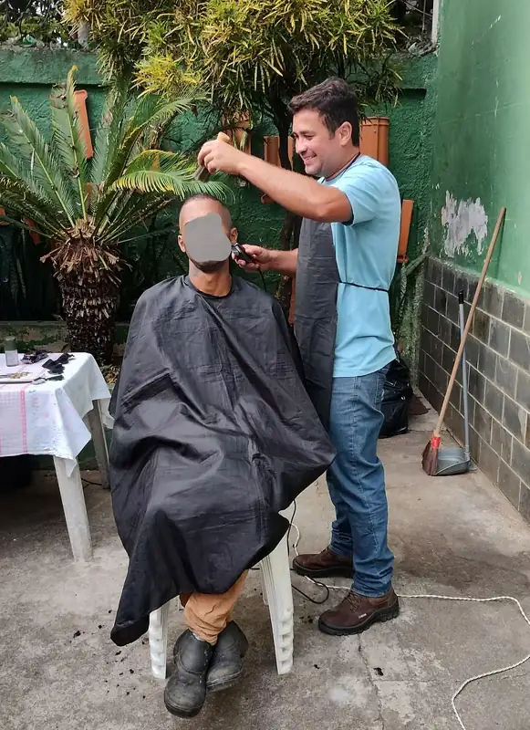 Voluntário cortando o cabelo de um assistido