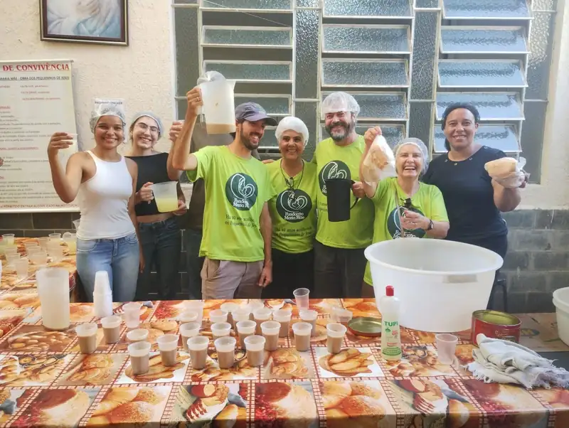 Voluntárias da Fundação Maria Mãe com a mesa do café da manhã servido aos assistidos